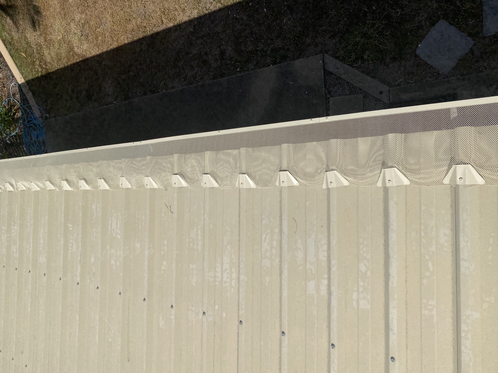 Gutter-edge installation — Colour-matched cream mesh